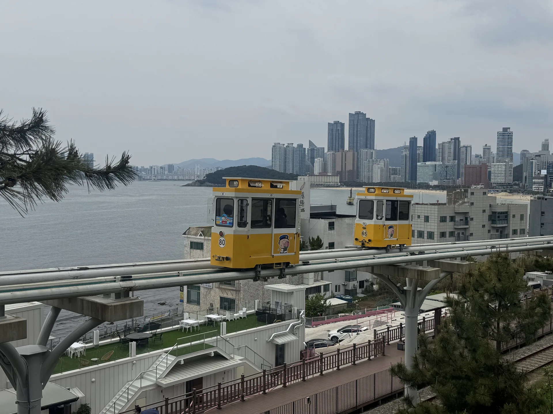 Pastelová kapsle Sky Capsule na vyvýšené pobřežní trati v Haeundae Blue Line Park v Busanu